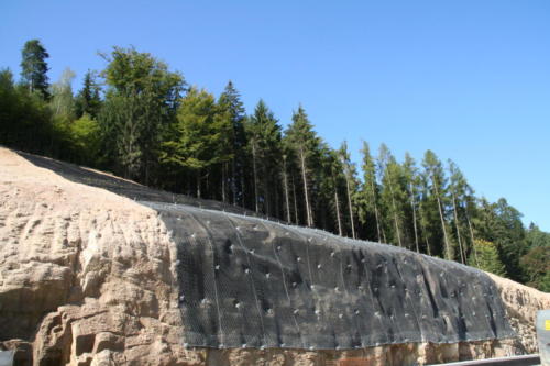 Pohled na zajištěný skalní masiv ocelovými sítěmi a georohoží